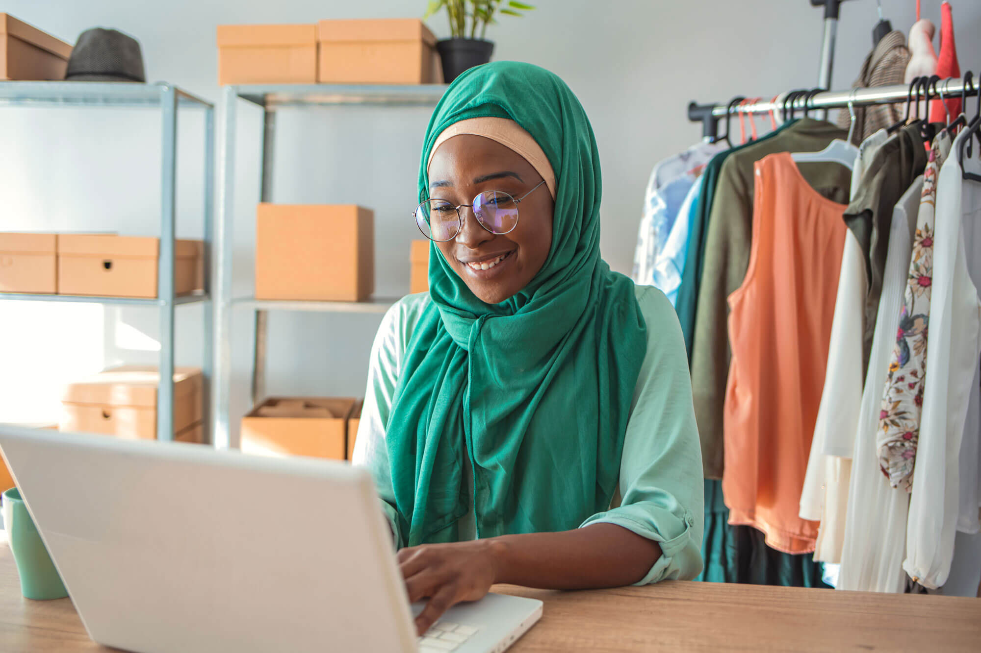 A small business owner working on a laptop, writing email content and building an email list from scratch for a marketing campaign.
